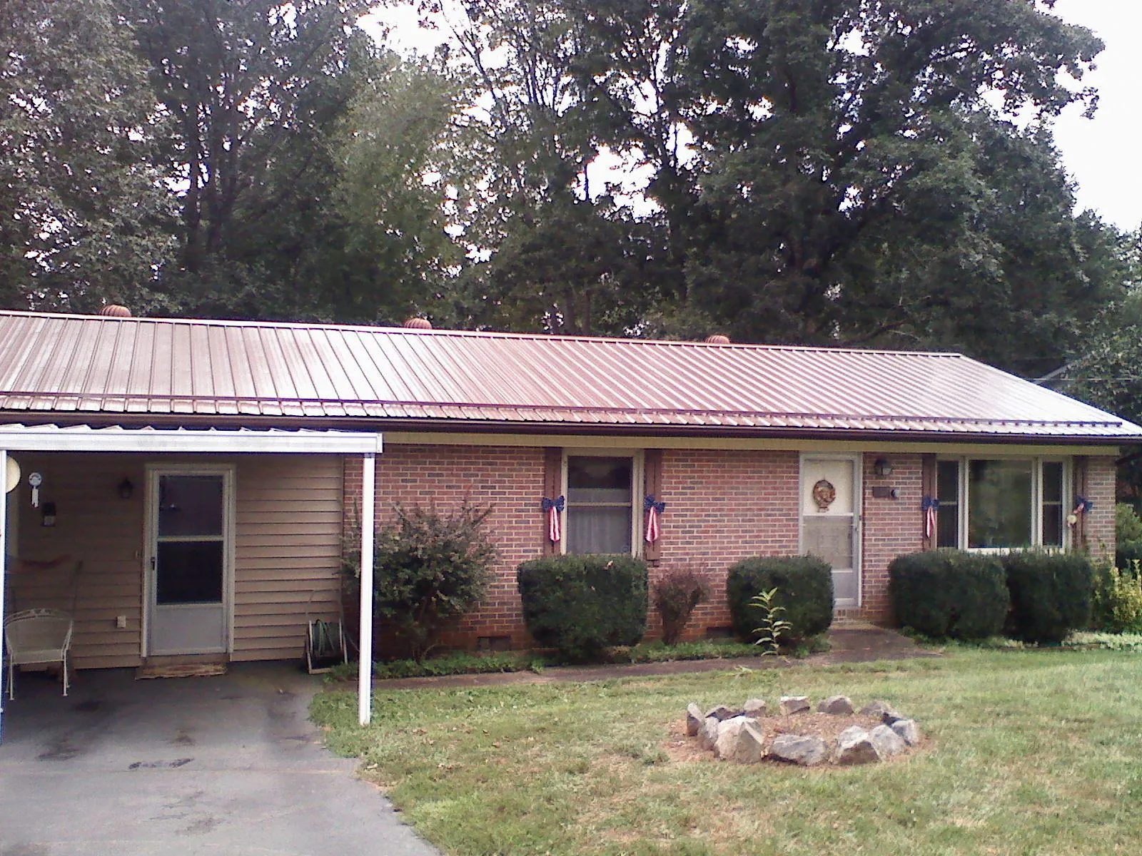 Bronze metal roof and carport on a brick ranch home — Roof Repair work by our crew in West Newton